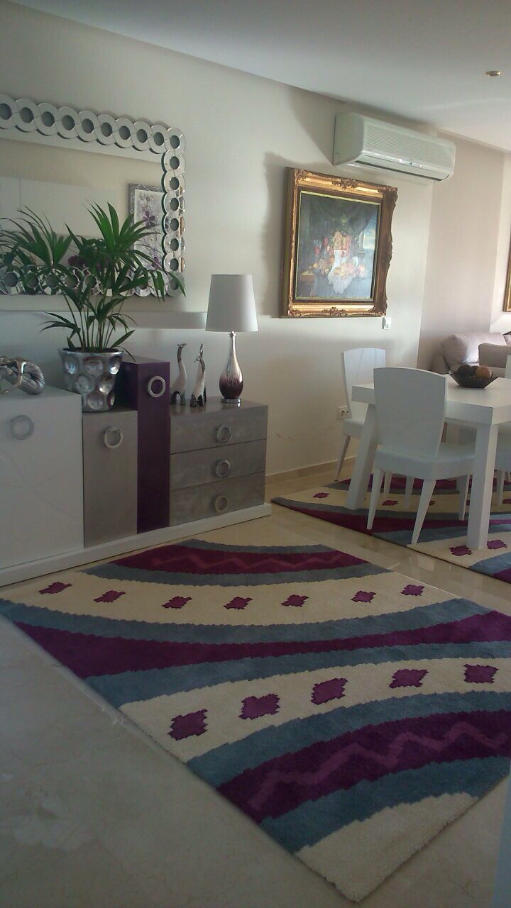 Imagen de ambiente de salón, que nos envía nuestra cliente de Cadiz Apartments, por su buena experiencia de compra, en tonos claros combinado con una alfombra Tattoo en colores crema, malvas y grises.