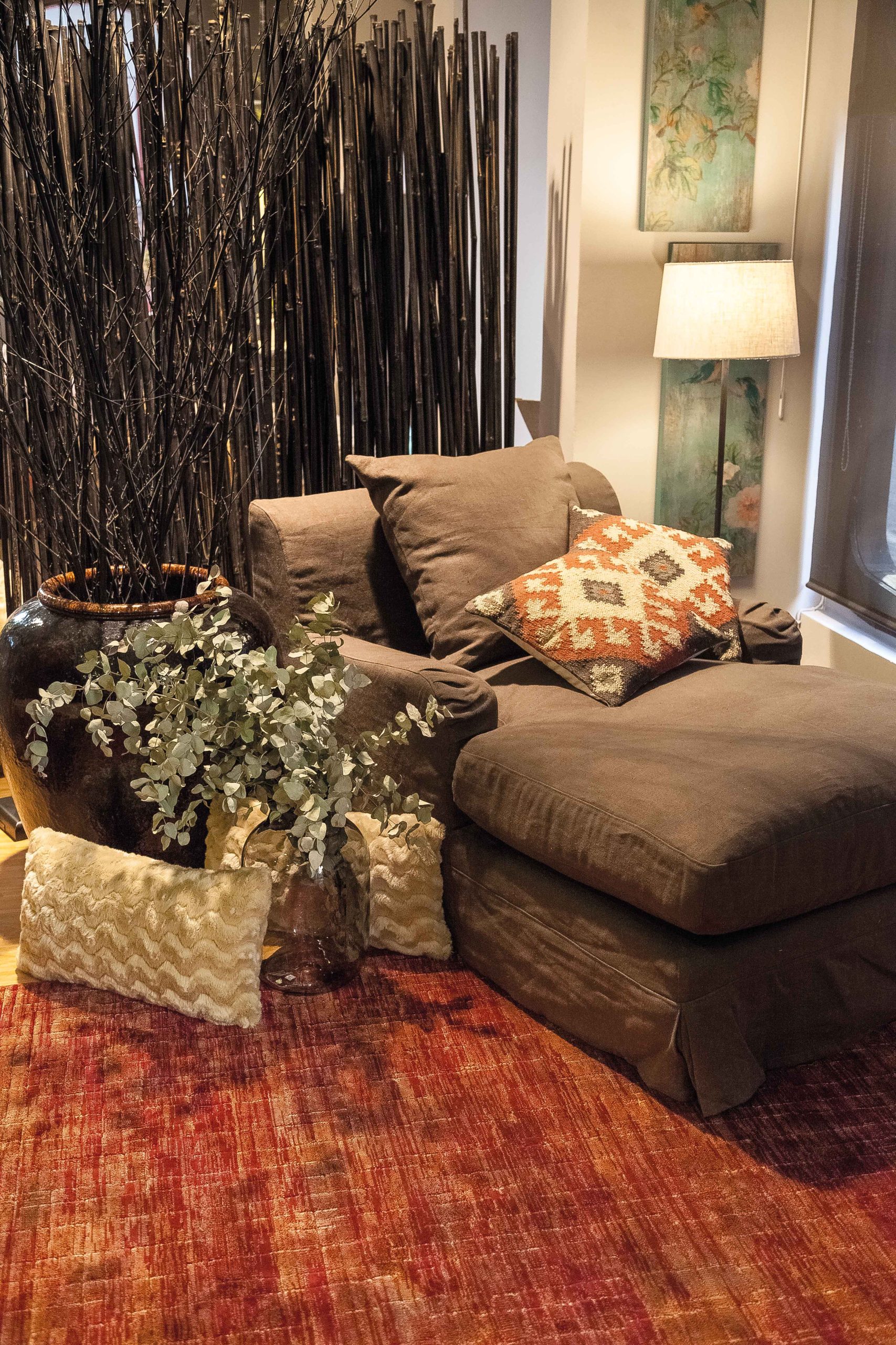 Ambiente decorado siguiendo las directrices del neurointeriorismo, con una zona de descanso en un salón, con un sofá con asientos deslizantes, y decoración zen